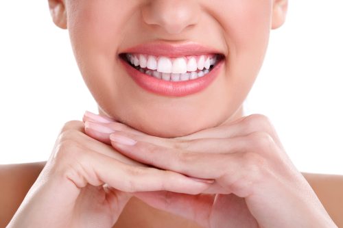 lady with perfect white teeth showing how to avoid Invisalign aligner staining