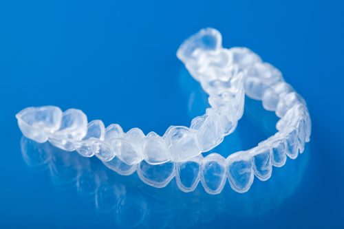 Invisalign clear aligners on a blue background in london